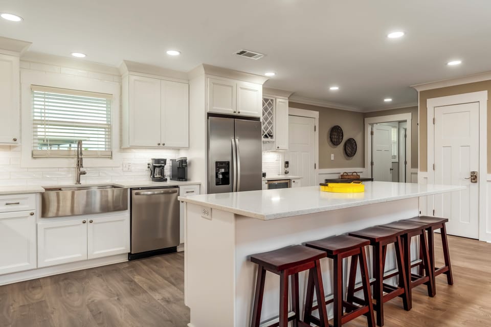 Gather around this spacious kitchen island where culinary adventures await, featuring modern stainless steel appliances and plenty of seating for memorable meals together.