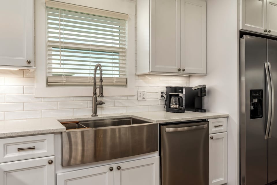 Your bright, fully-equipped kitchen features gleaming stainless appliances and a spacious farmhouse sink perfect for preparing meals together.