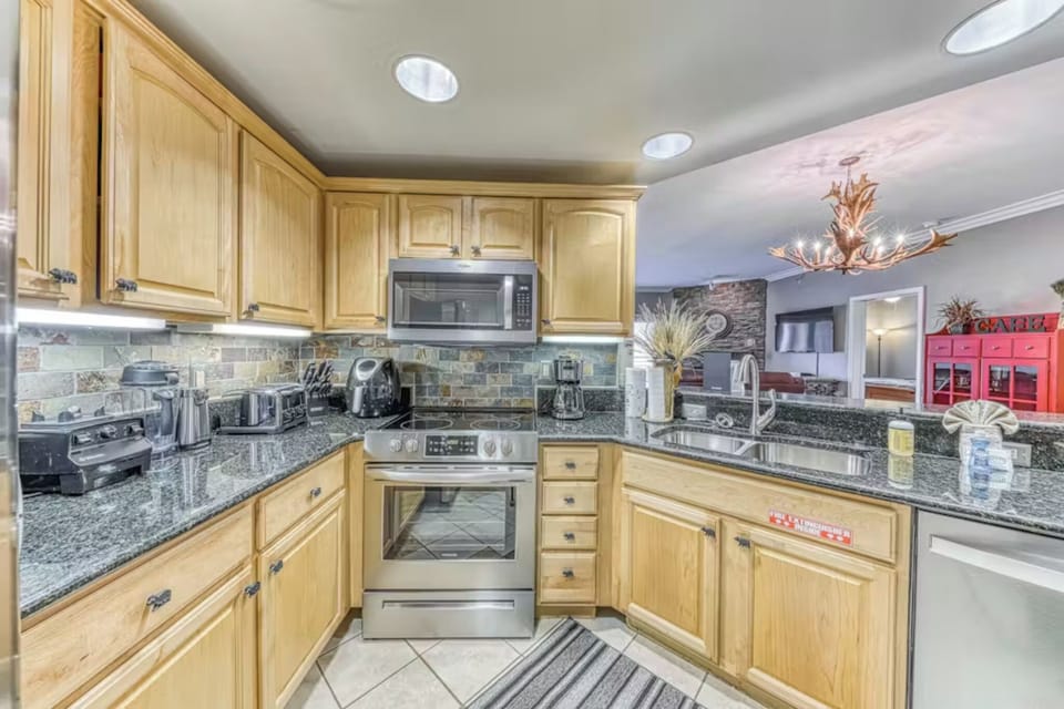 Your fully equipped kitchen features granite countertops, stainless steel appliances, and warm wood cabinets for all your culinary adventures.