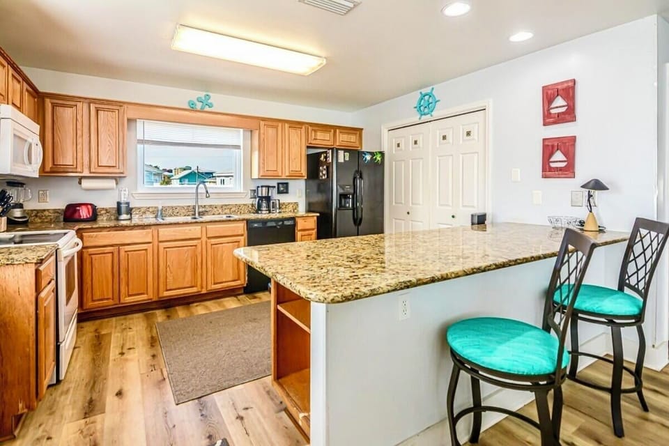 An open kitchen and bar area where everyone can gather while meals are prepared