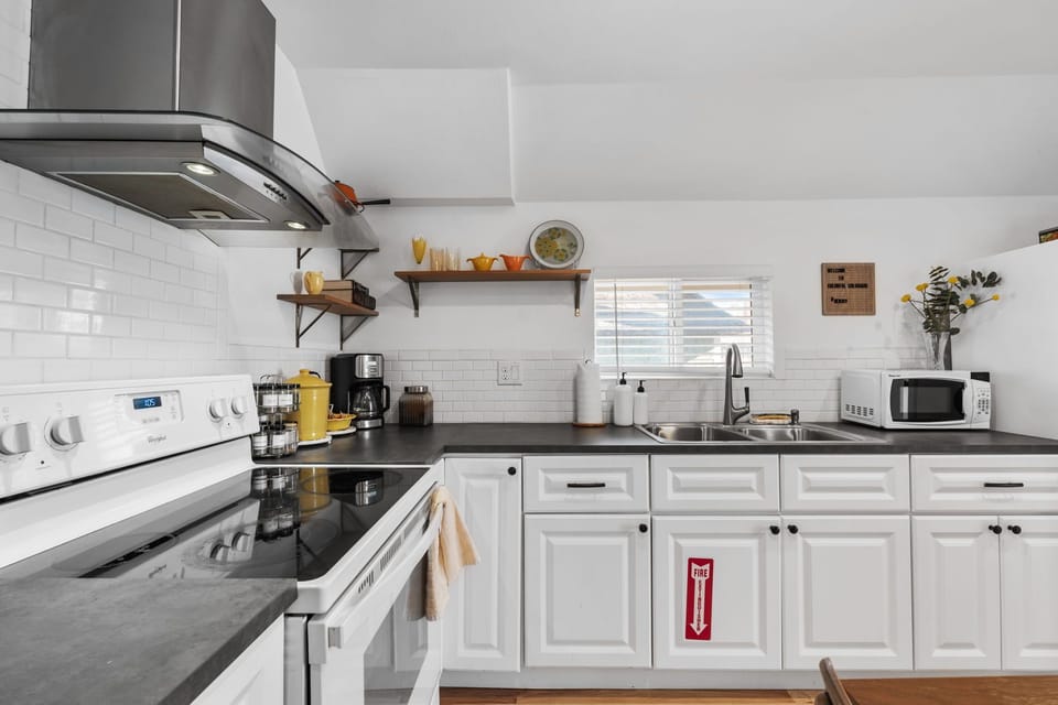 Your modern kitchen features sleek white cabinets, granite countertops, and everything you need for home-cooked meals during your stay.