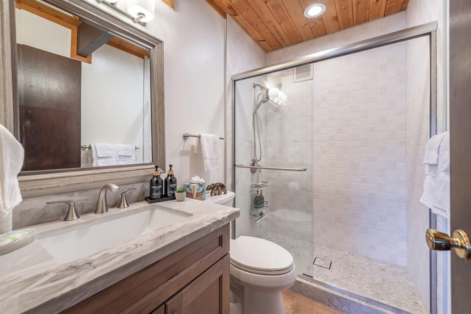 Unwind in your third bathroom featuring marble countertops and a glass shower.