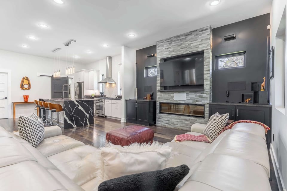 Bright open-concept living and kitchen with modern design and cozy fireplace