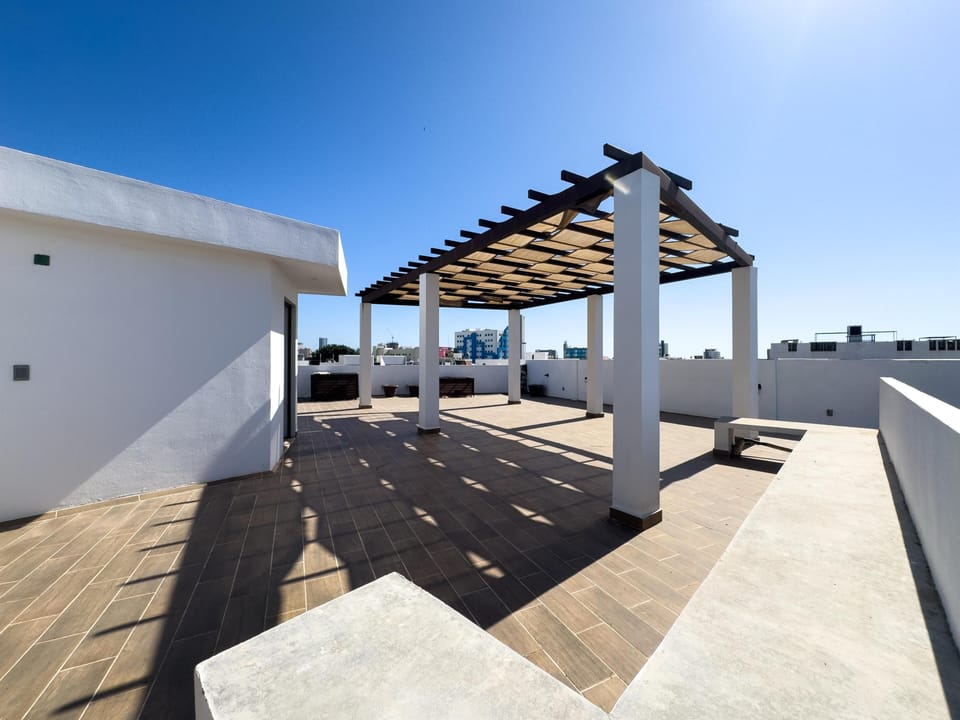 Spacious rooftop terrace with shaded lounge and city views