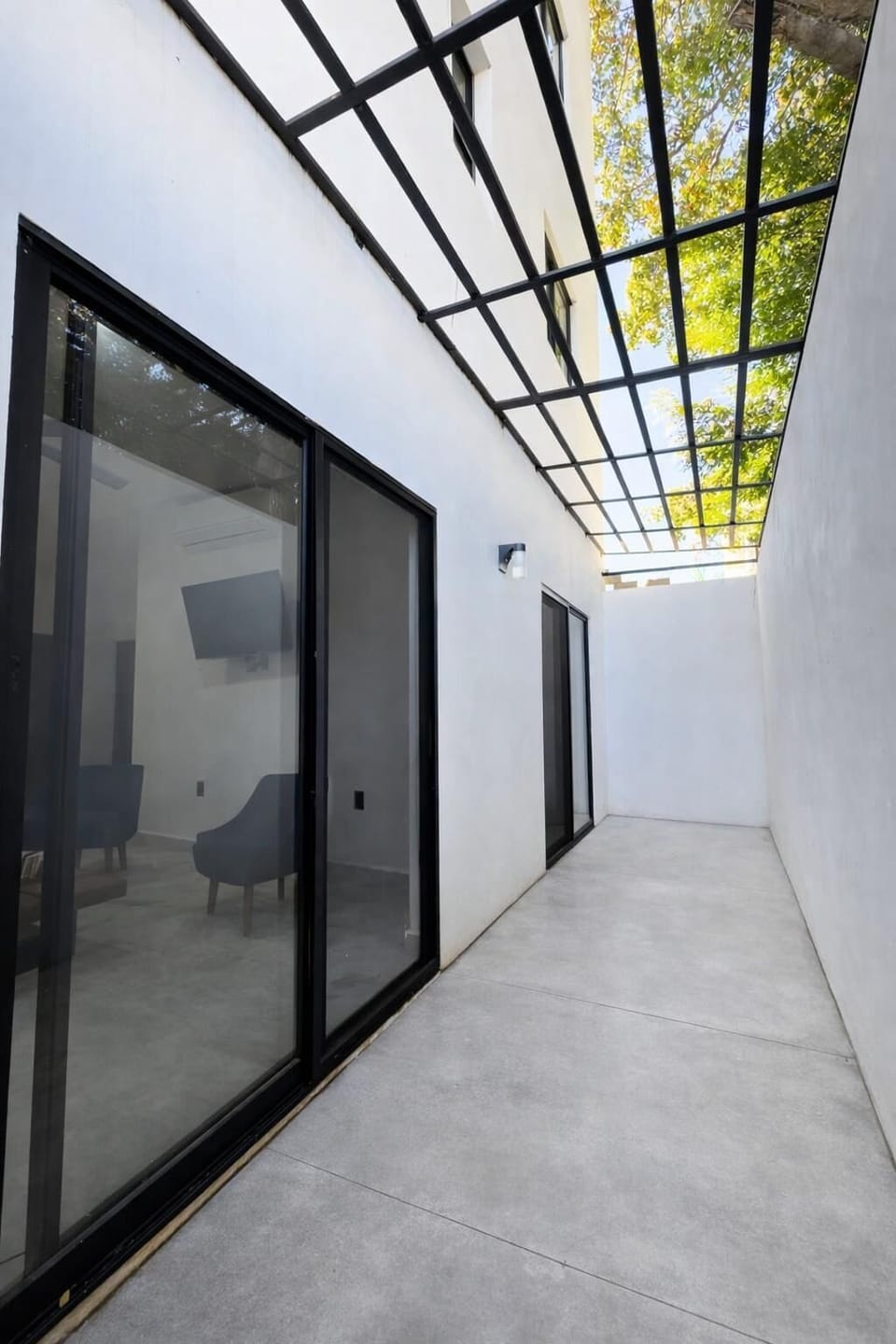 Bright, airy hallway with sleek glass ceiling and modern doors