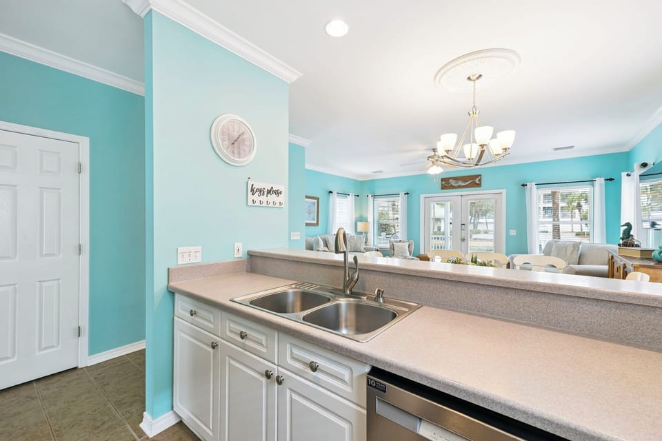 Your bright kitchen features sleek countertops and white cabinetry, perfect for preparing meals while staying connected to your loved ones in the open living space.