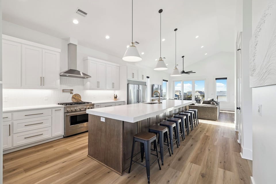 Your spacious gourmet kitchen features sleek white cabinets, premium appliances, and a stunning island perfect for cooking together.