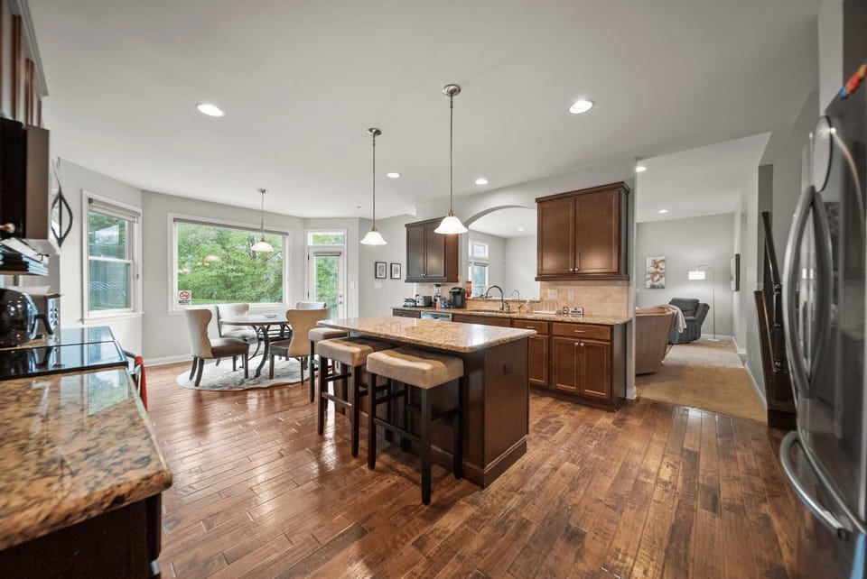 Open kitchen view w/ large island, bar seating & seamless flow into living areas