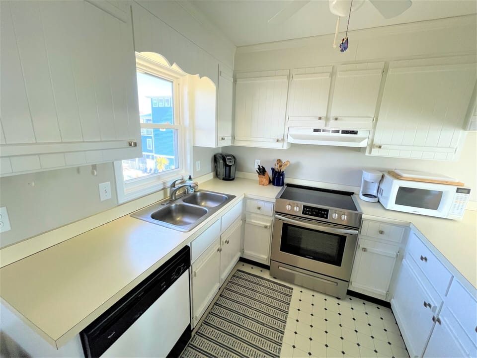 Your fully equipped kitchen awaits with modern appliances, ample counter space, and bright natural light streaming through the charming window—perfect for preparing meals during your stay.