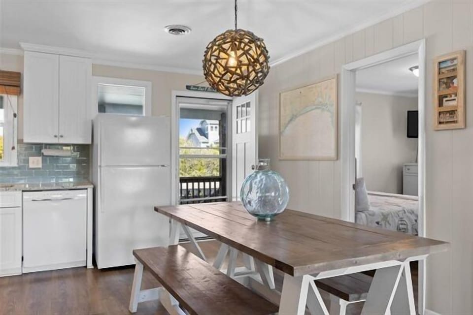 Your bright dining space features a beautiful wooden table perfect for morning coffee or evening meals with loved ones.