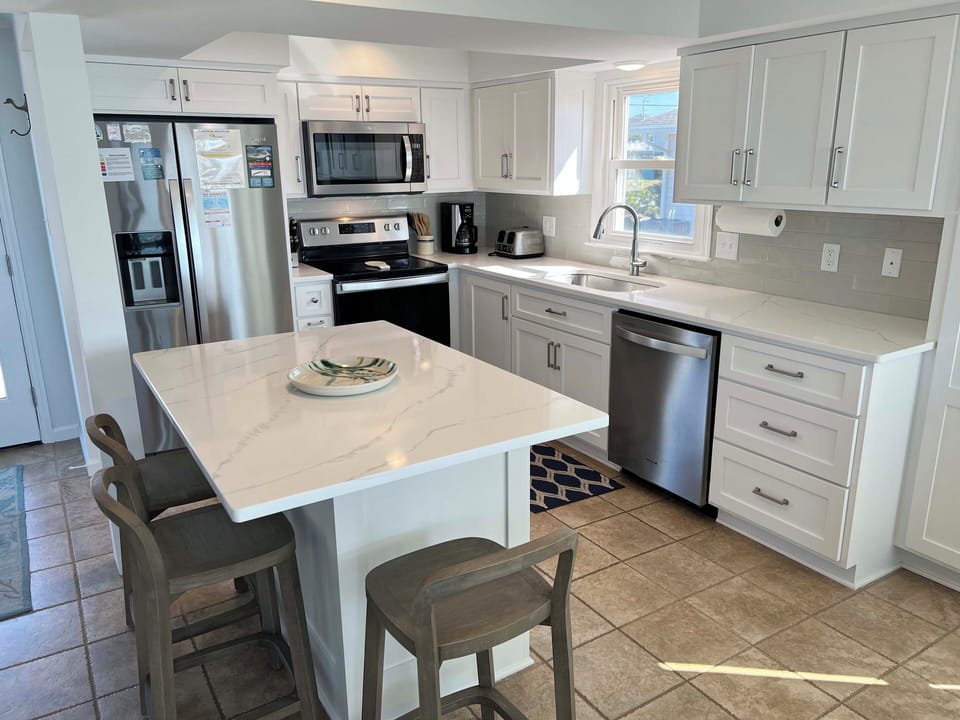 Your fully-equipped kitchen awaits with gleaming white cabinets, granite counters, and stainless appliances for effortless meal prep.