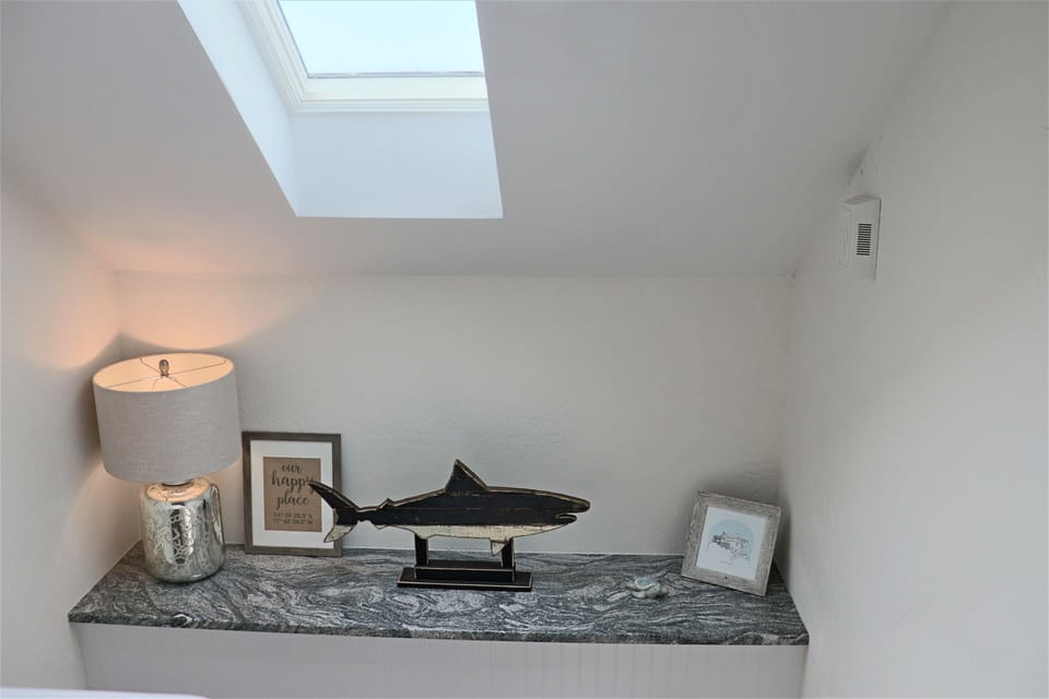 Your cozy loft nook features a charming display with natural light from the skylight above, creating a peaceful reading corner.