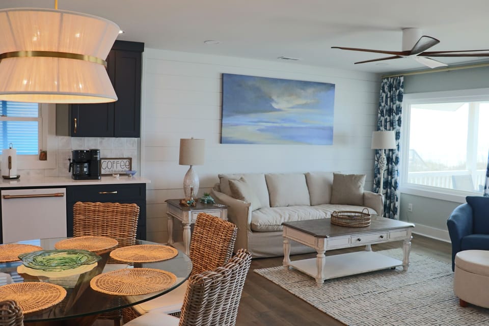 Relax in your coastal-inspired living space where ocean artwork and natural textures create the perfect beach getaway atmosphere.