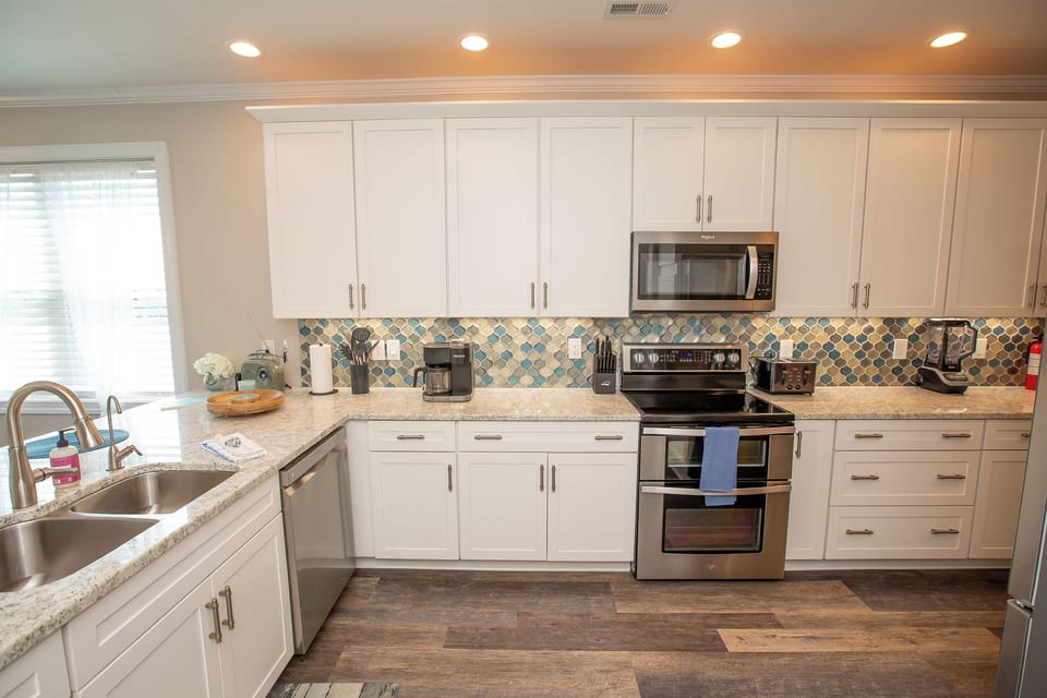 Your fully equipped kitchen features granite counters, stainless appliances, and a stunning mosaic backsplash for memorable meal prep.