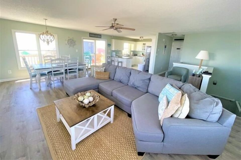 Relax in your spacious open-plan living area, where coastal comfort meets modern convenience with a full kitchen and dining space for memorable meals.