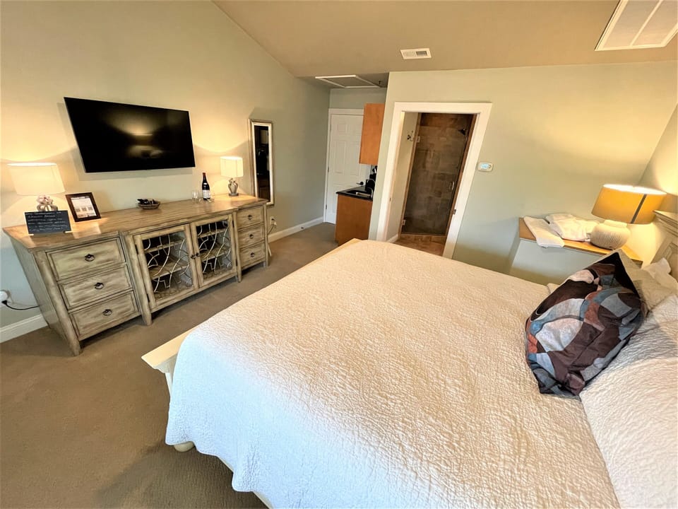 Relax in your spacious master suite with cozy bedding, entertainment center, and private ensuite bathroom for the perfect retreat.