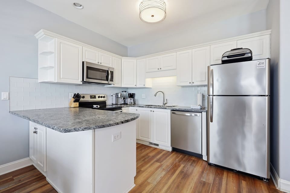 This modern kitchen features stainless steel appliances, granite countertops, and ample cabinet space—everything you need to prepare your favorite meals during your stay.