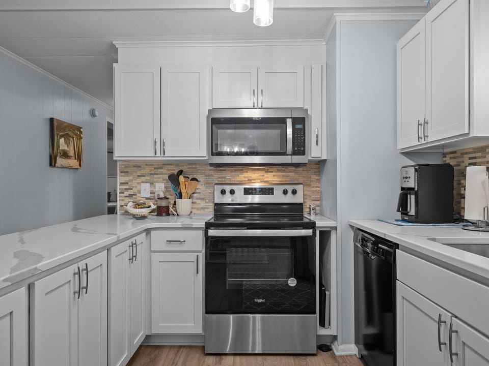 Your gourmet kitchen features crisp white cabinets, marble countertops, and modern stainless appliances for effortless meal prep.