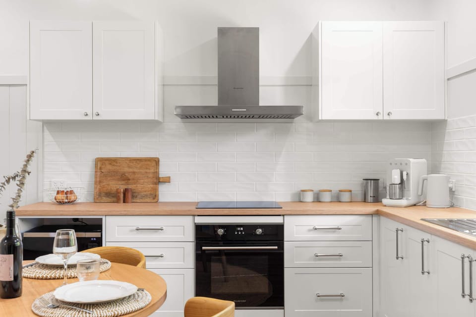 Stylish kitchen with crisp white cabinetry and timber benchtops