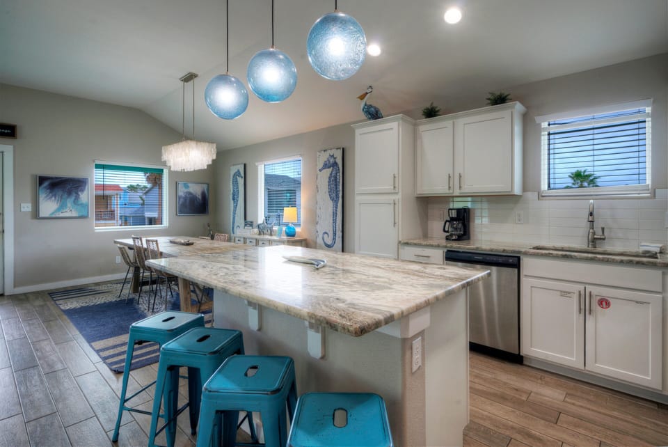 Modern kitchen with generous counter space, bar seating, and everything needed for easy vacation meals.