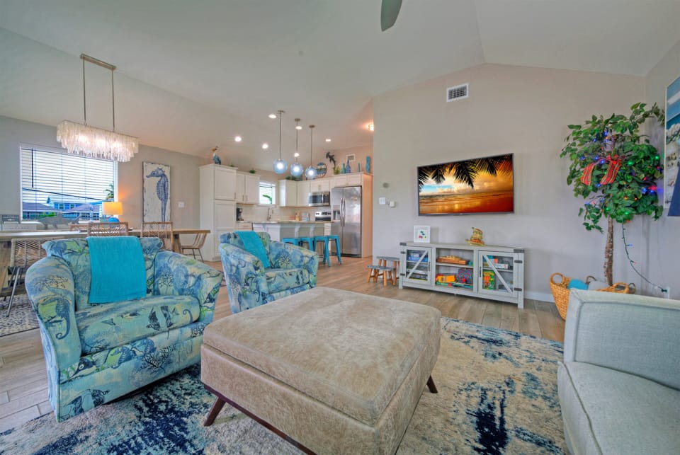 Inviting lounge with plush seating, vaulted ceilings, and a cozy setup for movie nights after the beach.
