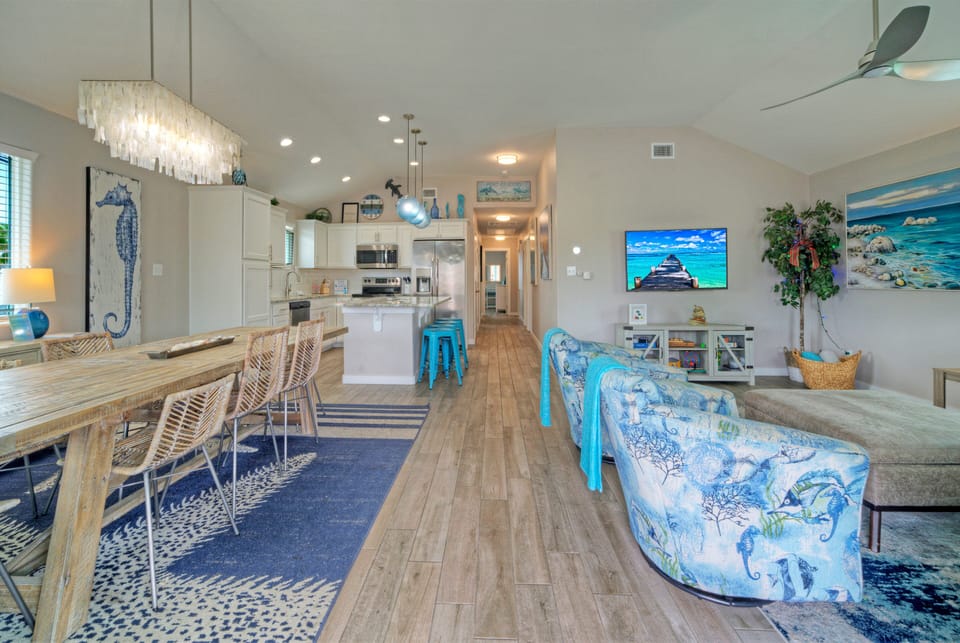 Bright, open living space with coastal touches, dining for the group, and a fully equipped kitchen at the heart of the home.