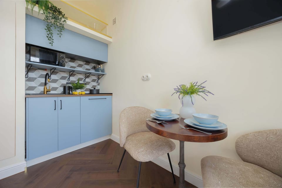 A small dining nook with a round table and two chairs. A plant centerpiece adds freshness to the area.