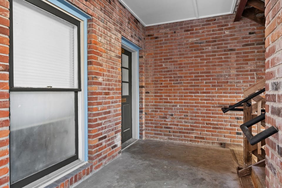 Covered brick entry with the marked door to Unit 210.