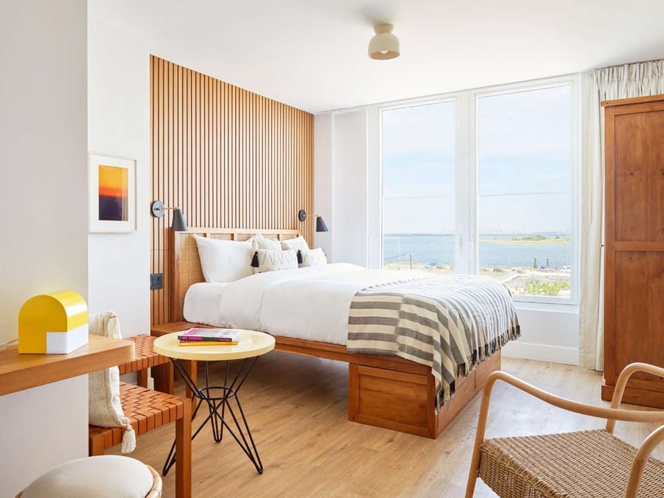 King bed facing bay view through tall windows
