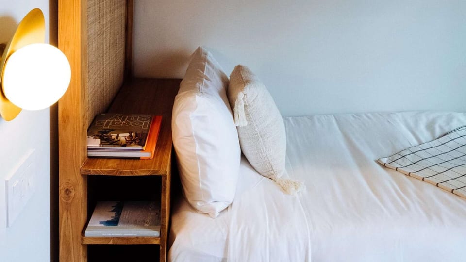 Bedside shelf with globe sconce and stacked books
