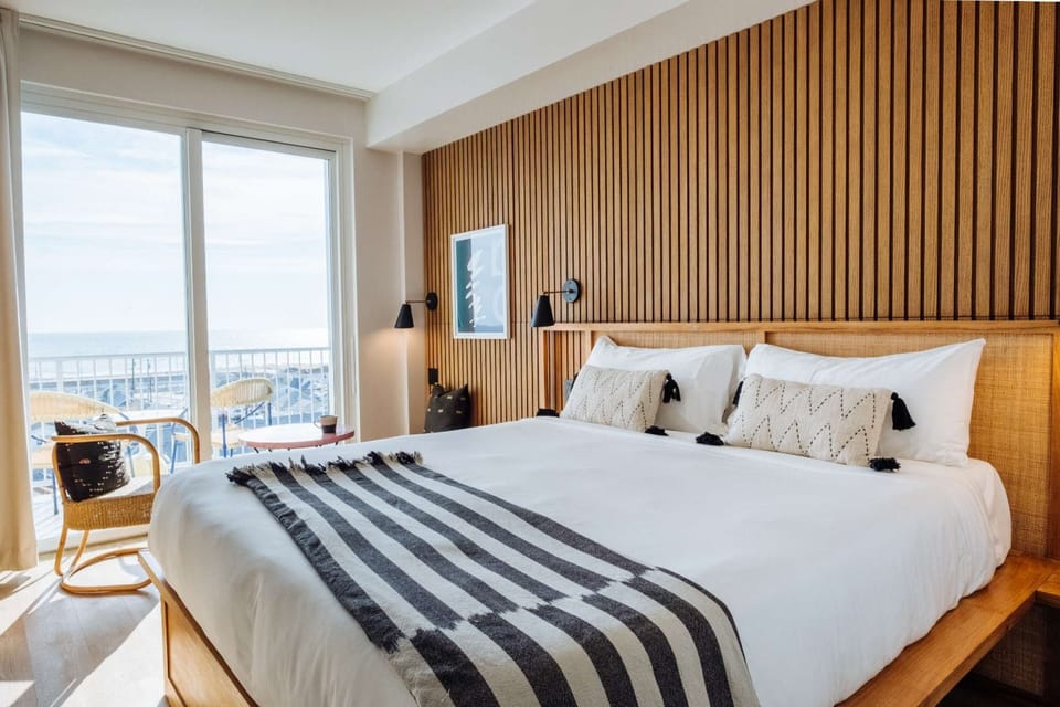 Deluxe King Ocean with Terrace - King bed with striped throw and ocean terrace