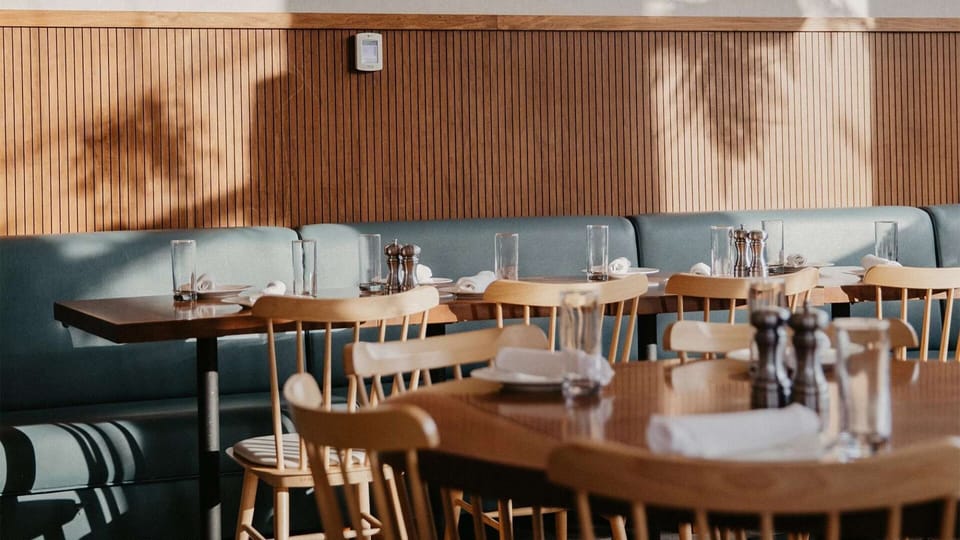 Dining seating with wood tables and soft afternoon shadows