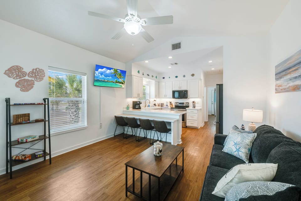 Relax in your bright, open-concept space with coastal charm, modern kitchen, and comfortable seating perfect for unwinding after beach adventures.