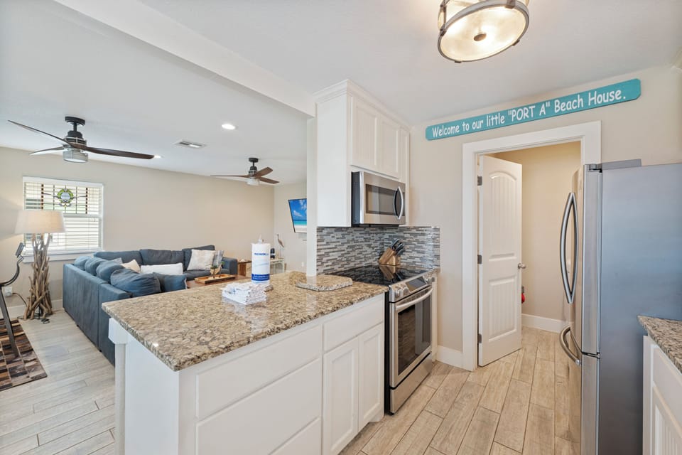 Welcome to your beach house escape! This open kitchen flows into the living area, perfect for cooking and gathering.
