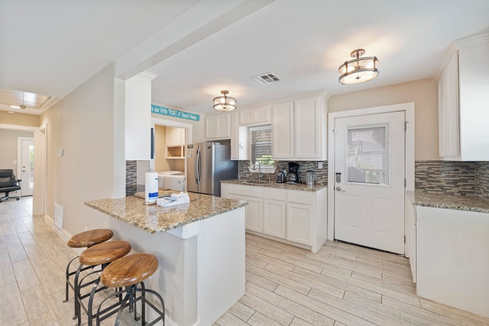 Your bright, modern kitchen awaits with granite counters, stainless appliances, and a breakfast bar perfect for morning coffee.