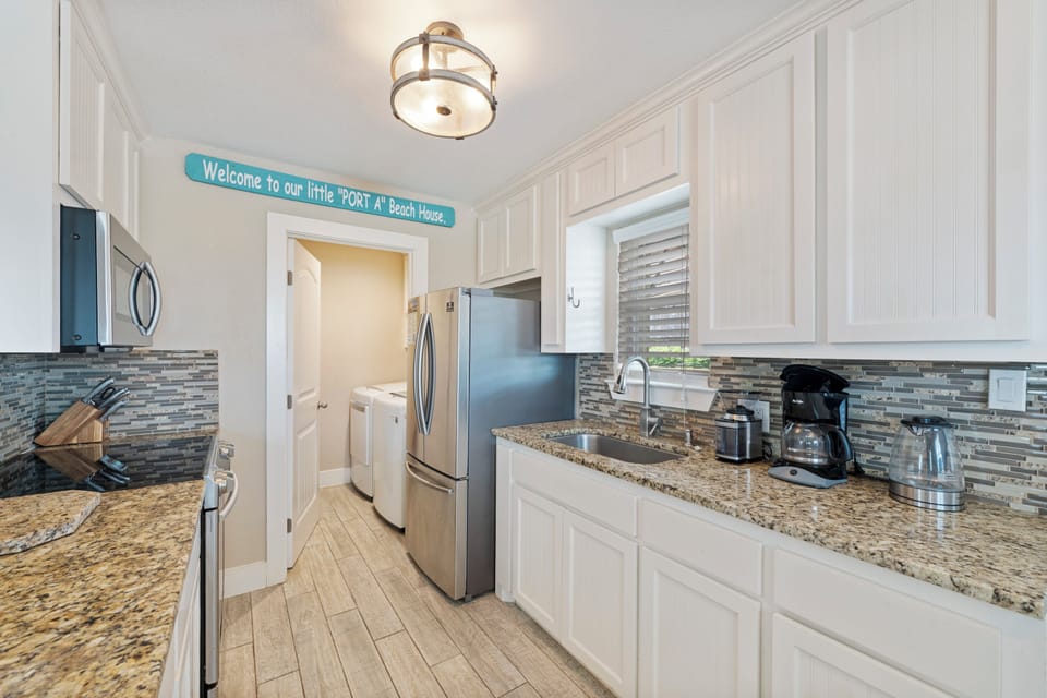 Your fully-equipped kitchen features granite counters, modern appliances, and coastal charm—perfect for preparing meals during your beach getaway.