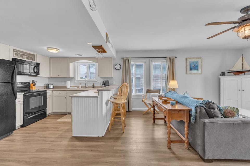 Relax in your bright open living space where coastal charm meets modern comfort, complete with full kitchen and cozy seating area.