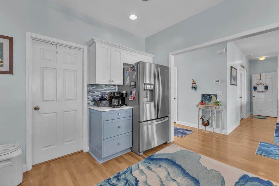 Your bright coastal kitchen features modern stainless appliances and charming blue accents that create a relaxing seaside atmosphere.