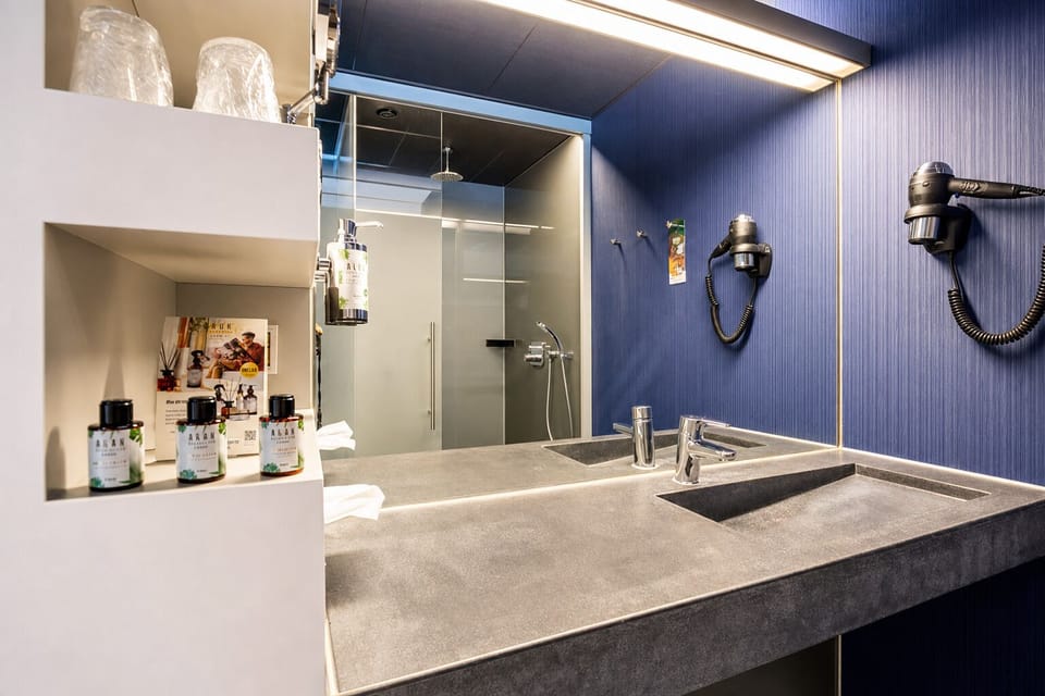 Refresh under a rainfall shower beside a spacious vanity.