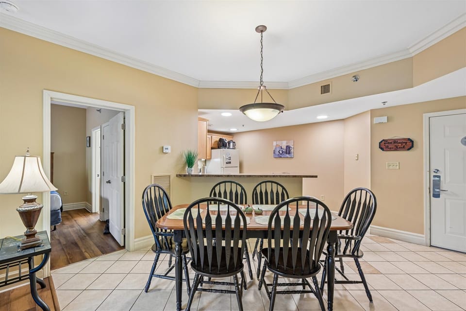 Gather around your spacious dining table for six, where warm lighting creates the perfect atmosphere for family meals and evening conversations.