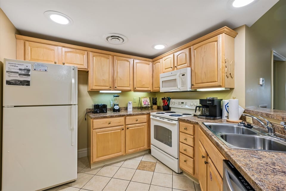 Your fully equipped kitchen awaits with everything needed for home-cooked meals. Granite counters, full appliances, and warm wood cabinets create a comfortable cooking space.