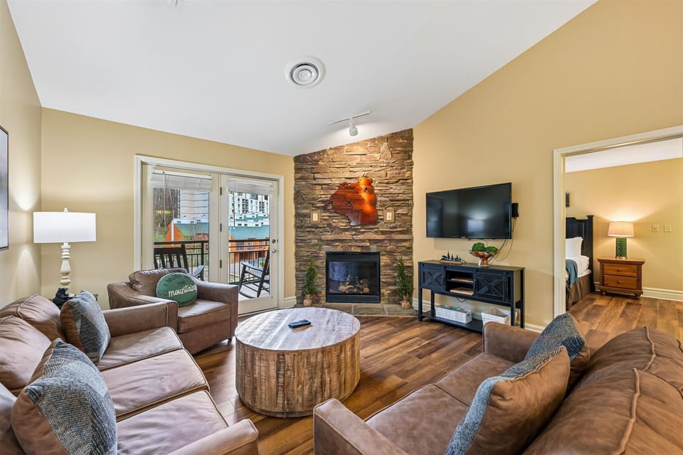 Sink into plush leather seating by your stone fireplace, where warmth meets modern comfort in this inviting living space.