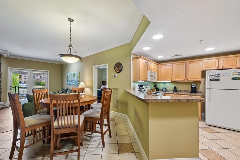 Your open-concept kitchen flows seamlessly into the dining area, perfect for preparing meals and gathering together in this bright, welcoming space.