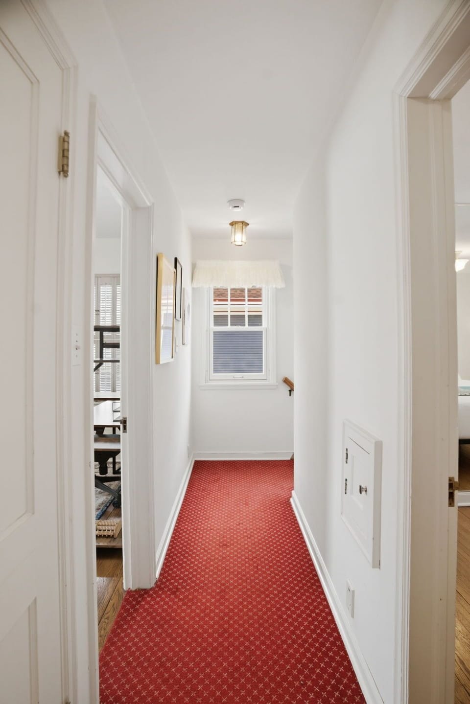 Step into your bright hallway where crisp white walls and elegant red carpet guide you through your home away from home.