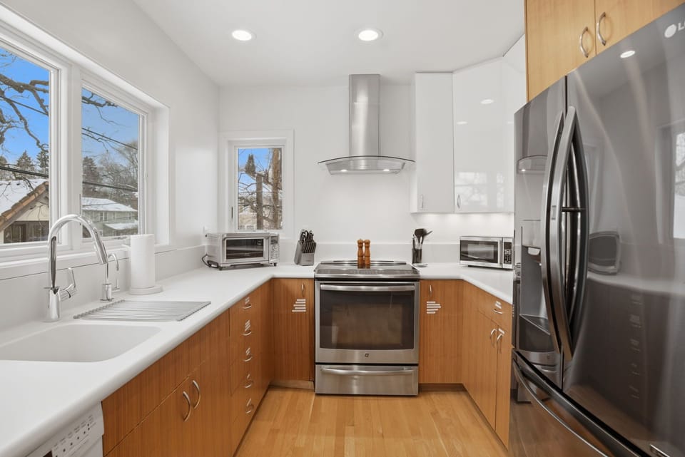 Your modern kitchen features stainless steel appliances, warm wood cabinetry, and bright natural light from large windows overlooking the peaceful neighborhood.