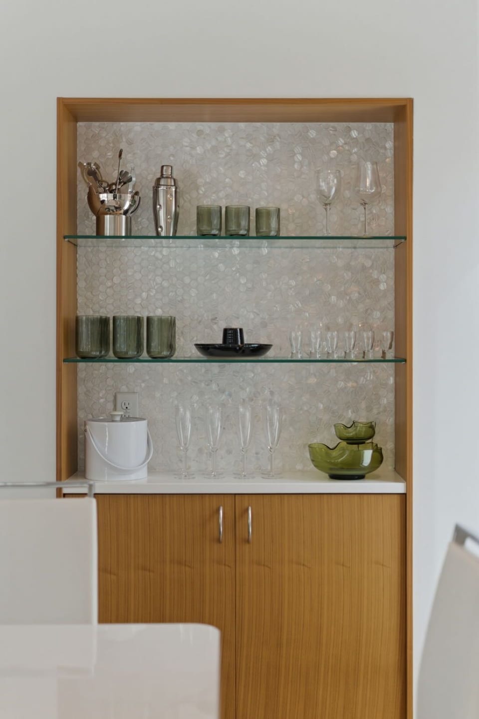Your stylish bar area features elegant glassware and cocktail essentials, perfect for crafting evening drinks in sophisticated comfort.