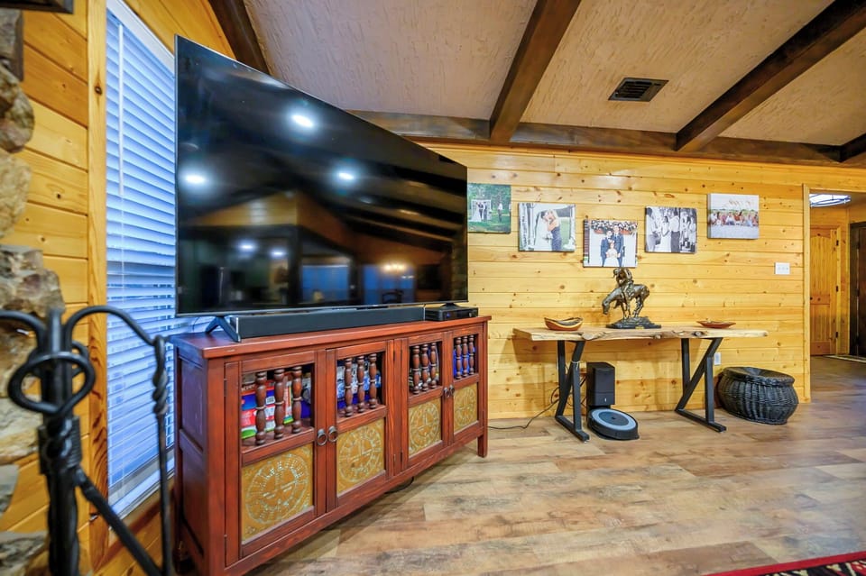 Unwind in this rustic living room with warm wood walls, a large TV for movie nights, and cozy seating areas perfect for relaxing.