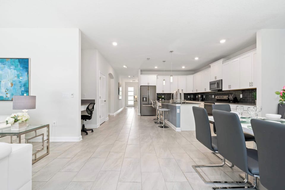 A grand view of the seamless flow between the kitchen, dining area, and sun-drenched lounge.