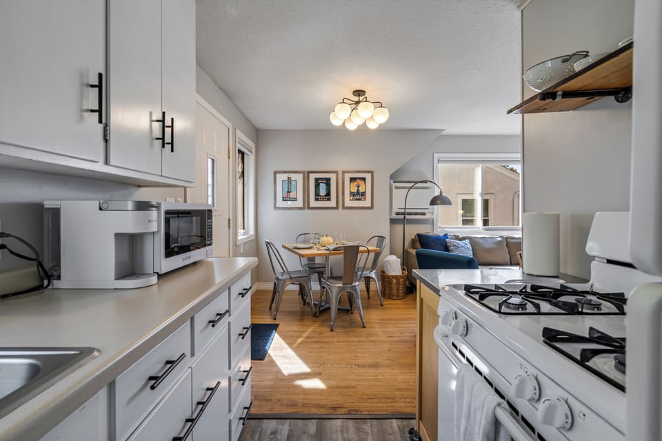 18 — Upper Kitchen Open to Dining and Living Room with Natural Light