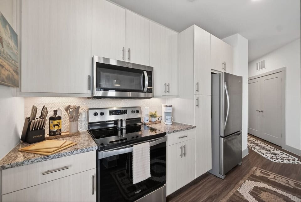 Kitchen: Fully equipped kitchen featuring stainless steel appliances, coffee maker, and all essentials for home-style meals.